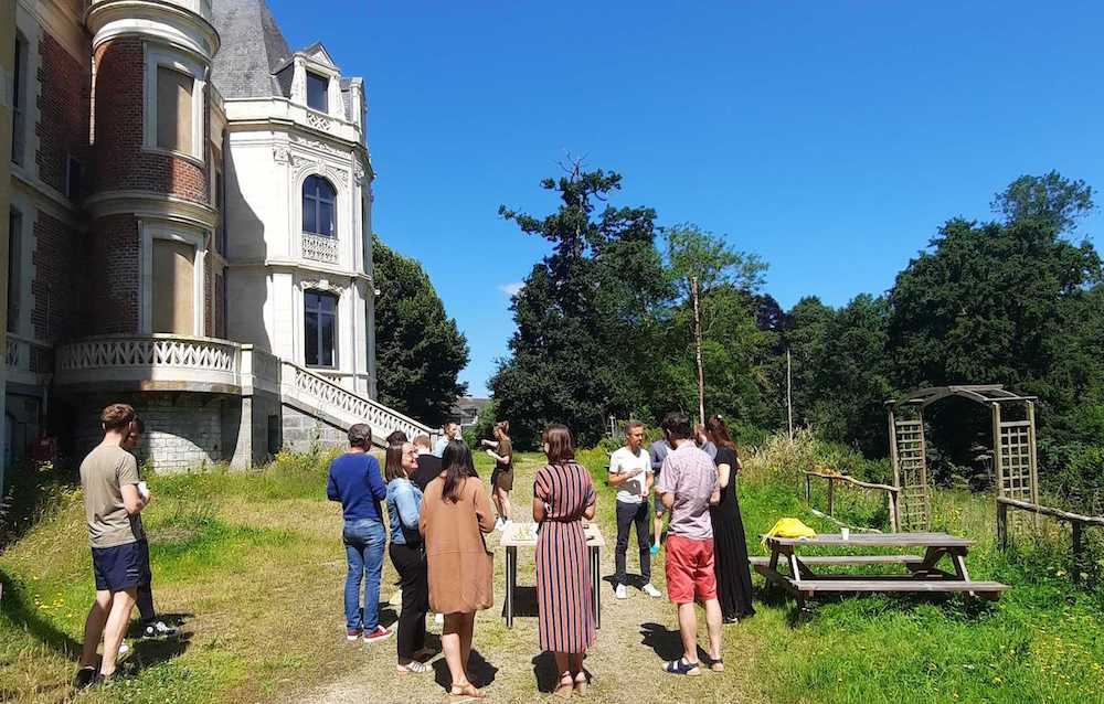 Groupe de collaborateurs dehors qui discutent, derrière l'Ubiplex